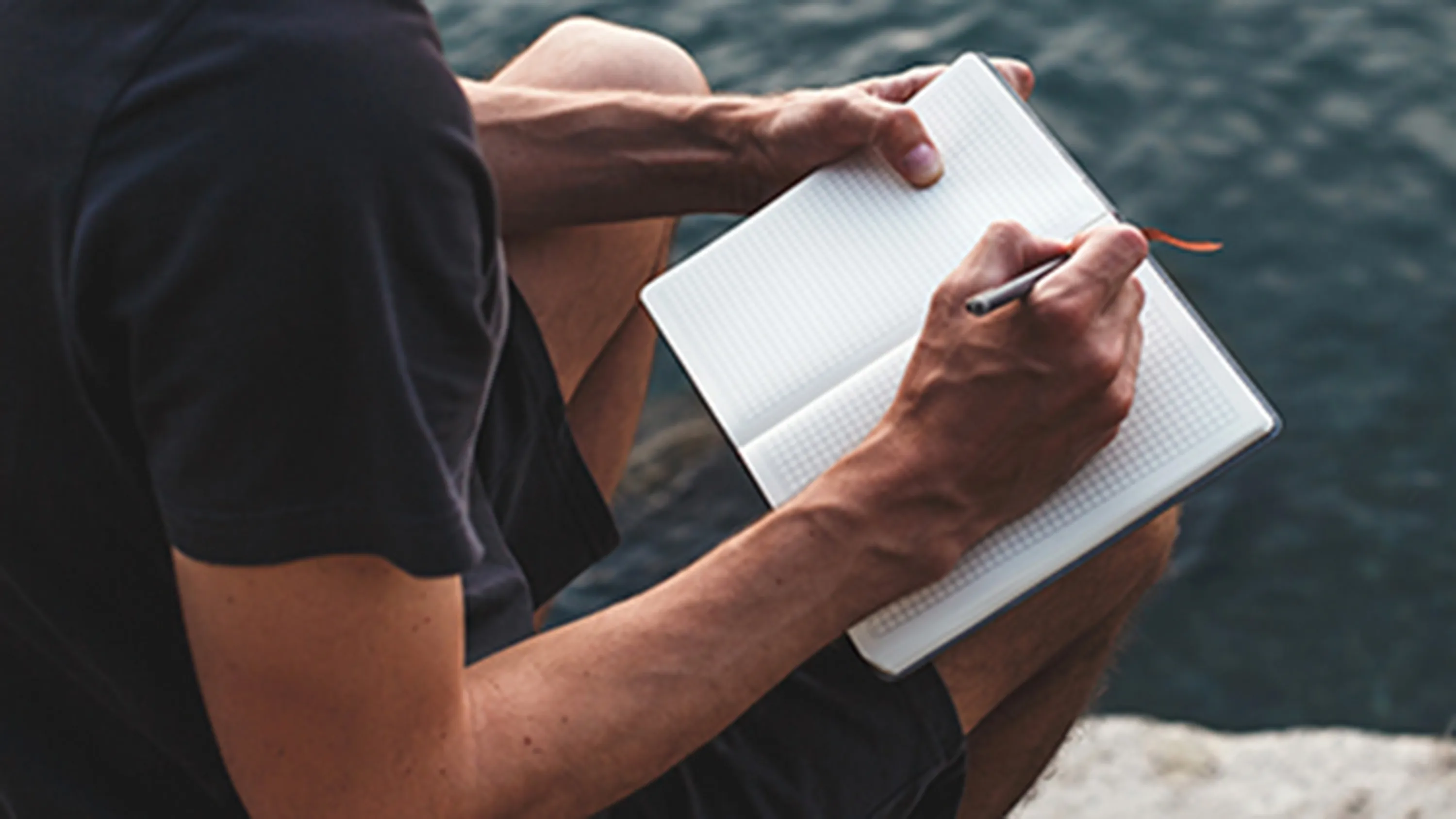 Mann schreibt in einem Notizbuch